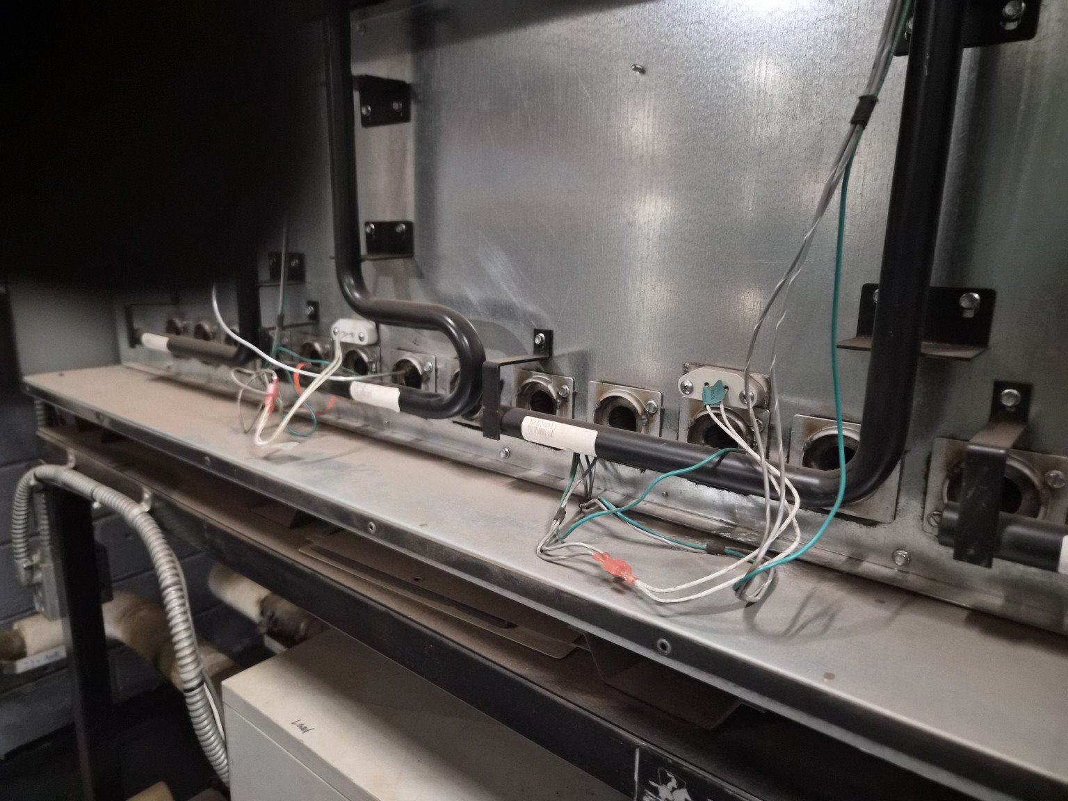 Boiler burner compartment showing ignition wiring and burner connections during service.